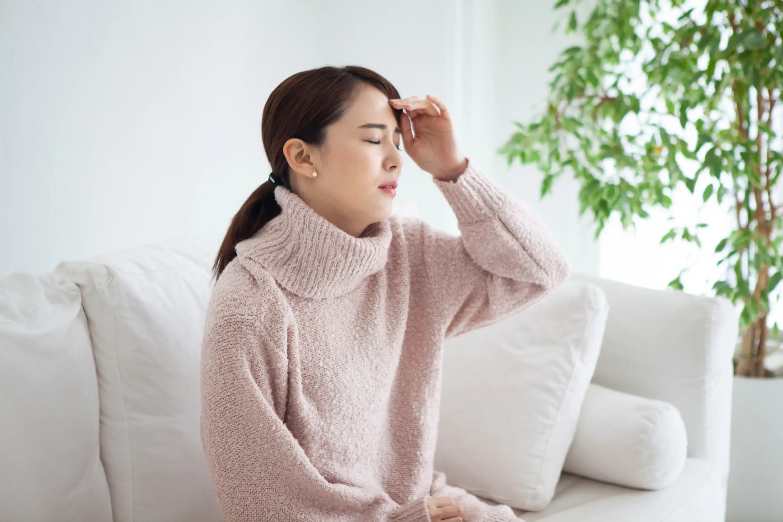 頭をおさえる女性