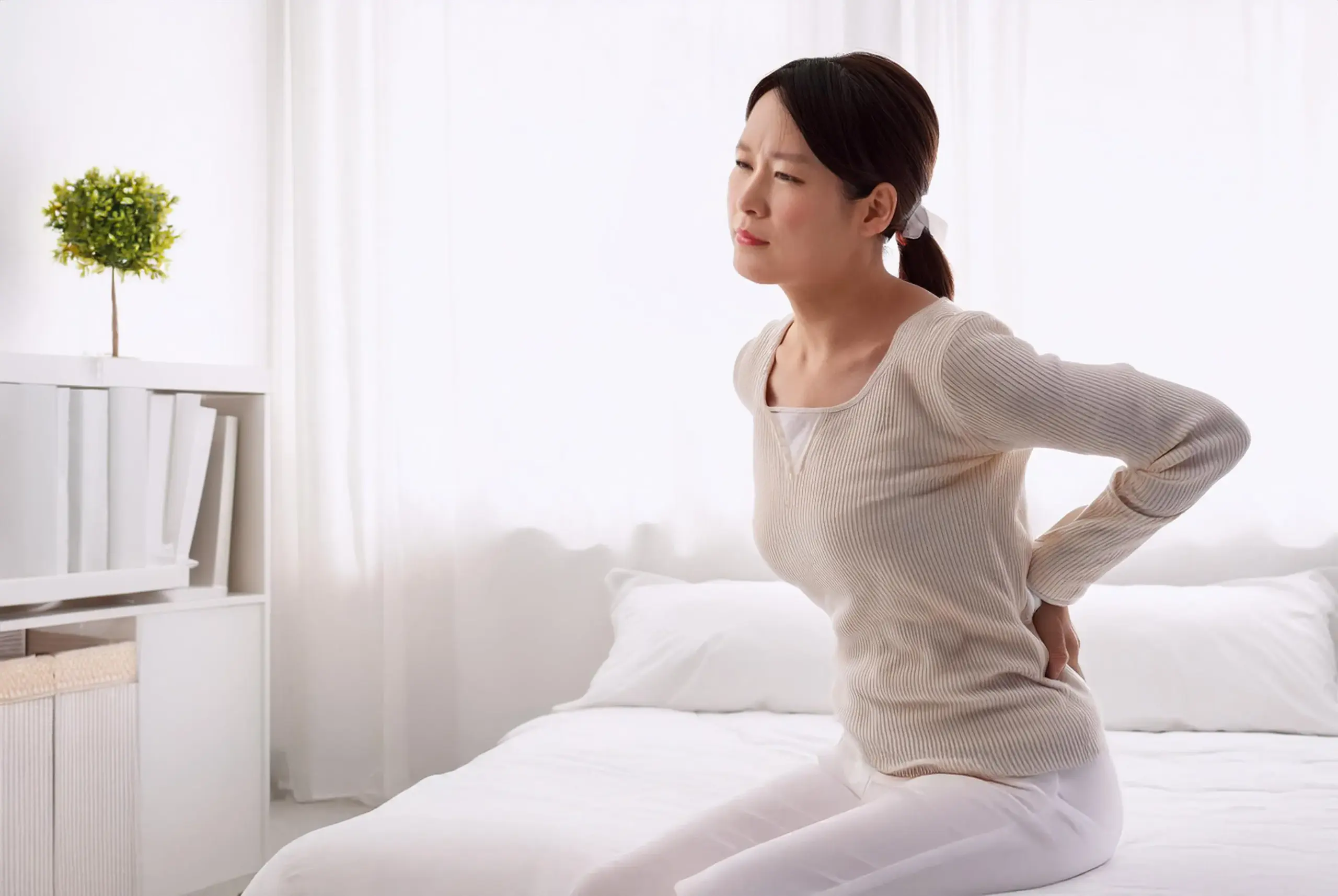 腰をおさえる女性