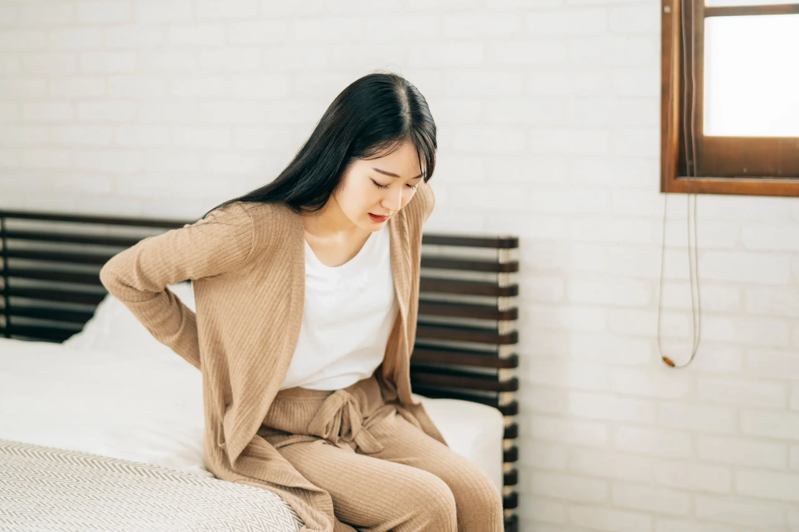 腰をおさえる女性